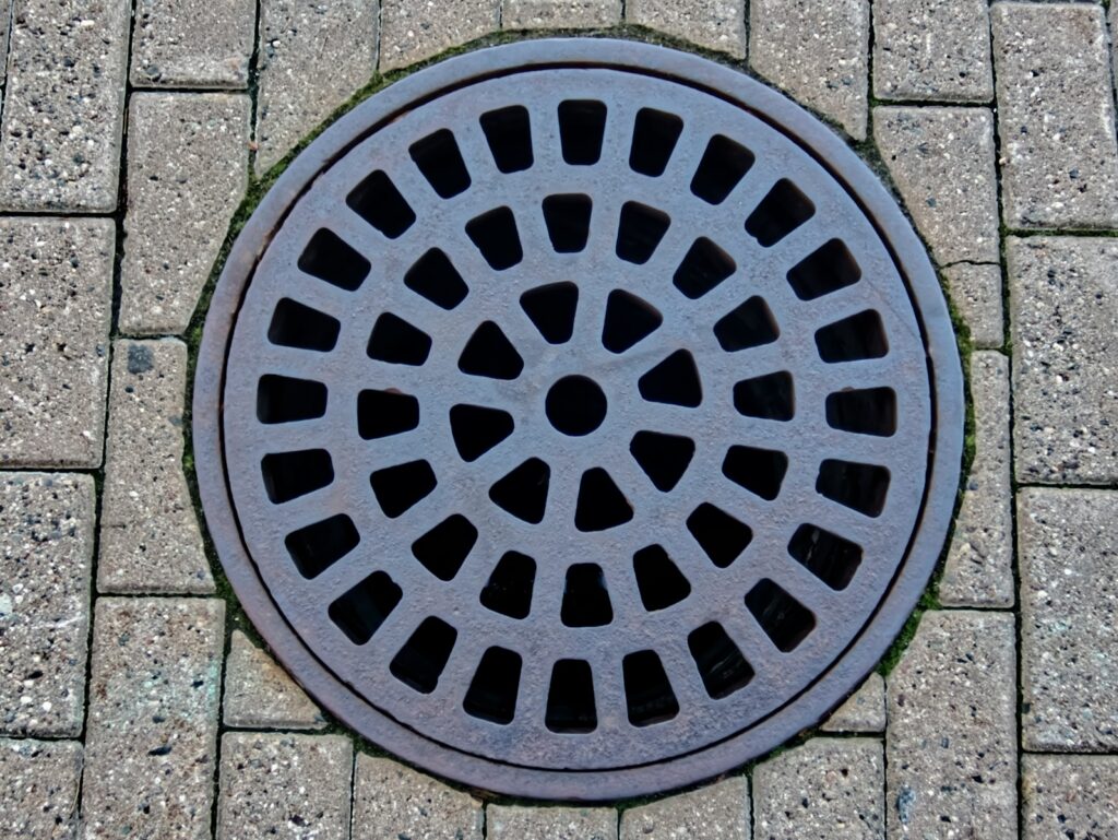 a manhole cover on a brick sidewalk